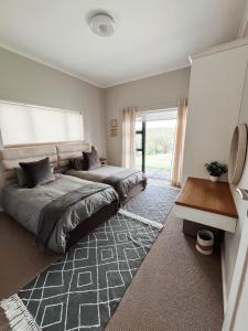 a bedroom with two beds and a window at Witsand Whalecliff accommodation in Witsand