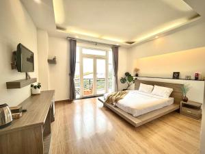 a bedroom with a bed and a television in it at K HO DISCOVERY Guest House in Da Lat
