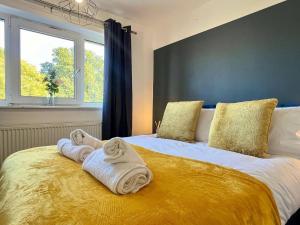 1 Schlafzimmer mit 2 Handtüchern auf einem Bett mit Fenster in der Unterkunft Long Stay 3br Parking Wifi in Corby