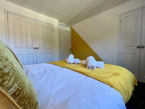 ein Schlafzimmer mit zwei ausgestopften Tieren auf einem Bett in der Unterkunft Long Stay 3br Parking Wifi in Corby