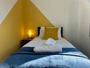 ein Schlafzimmer mit einem Bett mit zwei Handtüchern darauf in der Unterkunft Long Stay 3br Parking Wifi in Corby