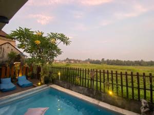 a pool in a house with a fence at Mahesa House by SHM in Ubud