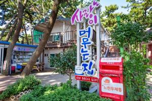 a sign for a restaurant in front of a building at Sarangiimeomuneunjip Pension in Taean