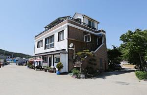a tall brick building with a clock on it at Taean Gaetyeowool Pension in Taean