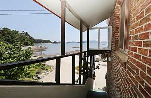 a view of the beach from the balcony of a house at Taean Gaetyeowool Pension in Taean