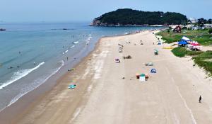 a group of people on a beach with the ocean at Hakahmpo Haneul Pension in Taean
