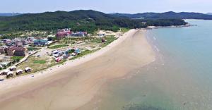 an aerial view of a beach with umbrellas at Hakahmpo Haneul Pension in Taean