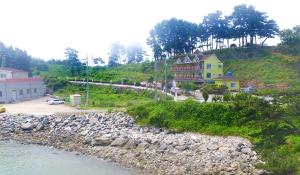 a house on a hill next to a body of water at Blue Heights in Boryeong +8 photos