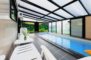 a swimming pool with white chairs and a swimming pool at Vine family and kids four season pool villa in Gapyeong +9 photos