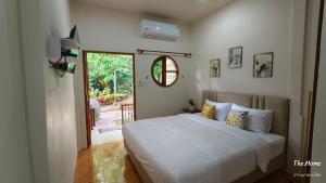 a bedroom with a large white bed and a window at Koh Mook The Home in Ko Muk