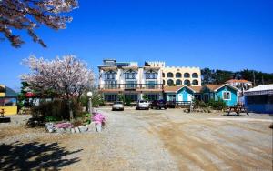 a large building on a dirt road in front at Silver Glowing Sea Pension in Taean