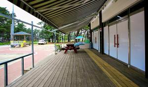 a porch of a building with a bench and a playground at Mongsanpohaebyeon Pension in Taean