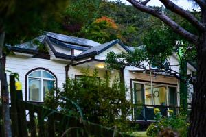 a white house with a gambrel roof at Giltara HaengWoon Pension in Gapyeong