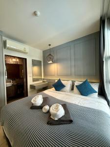 a bedroom with a large bed with two hats on it at Poolside 1 Bedroom Apartment by Renttini in Surin Beach