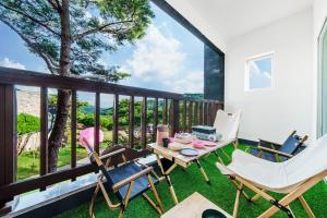 a patio with chairs and a table and a balcony with a view at Yesan Hiyella Kids Pension in Hongseong +12 photos