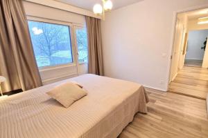 a bedroom with a bed and a large window at Villa Ruths Stay Kunta in Kouvola