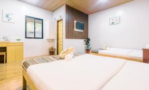 a room with two beds and a tv at Busai Dream Falls Resort in Loboc