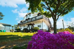 a house with purple flowers in front of it at Poeguenhan Pension in Taean
