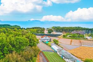 an aerial view of a train at a farm with the ocean at Poeguenhan Pension in Taean