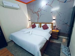 a bedroom with a bed and a wall with birds on it at Milestone Homestay Agra in Tājganj