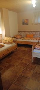three beds in a room with a tiled floor at Romantická chalupa na samote in Jahodná +14 photos