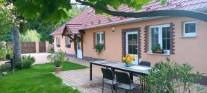 a house with a table and chairs in the yard at Romantická chalupa na samote in Jahodná