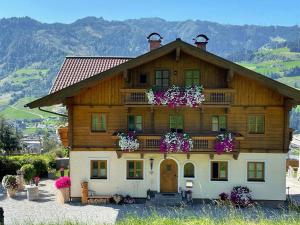 a large wooden house with flowers on it at Appartements Lehenhof in Sankt Johann im Pongau