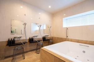 un bagno con vasca, doccia e lavandino di 福の家 a Minamiawaji Altre 21 foto