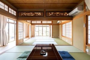 una camera con tavolo in una stanza con finestre di 福の家 a Minamiawaji