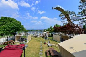 a group of tents in a yard with a bench at River Story Pension in Chuncheon