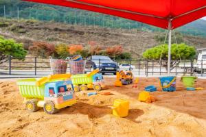 a toy truck in the sand under an umbrella at Pocheon Todam Kids Pool Villa All Kids Rooms in Pocheon