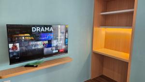 a flat screen tv sitting on a wall at Apartemen Permata Residences Homestay Baloi in Nagoya +2 photos