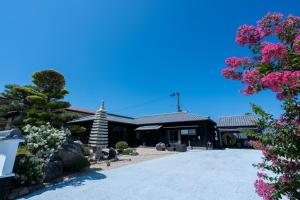 una chiesa con fiori rosa davanti di 福の家 a Minamiawaji