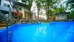 a large pool with blue water in front of a house at Namusori pension in Goesan