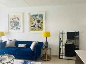 a living room with a blue couch and a table at Classy and Cozy 2 in Fourways