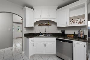 a kitchen with white cabinets and a sink at Modern rustic home in Olmito