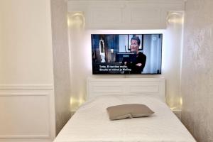 a bedroom with a bed with a tv on the wall at Villa Ruths Stay Lehmus in Kouvola