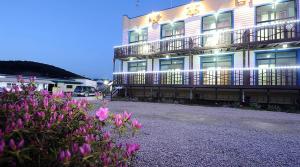 a building with pink flowers in front of it at Bangpo Sea Pension in Taean