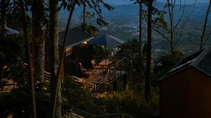 a house with a table and an umbrella at Bobocabin Dieng Pass, Batang in Bawang