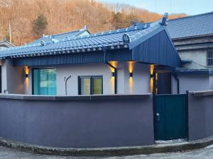 a house with a black roof and a fence at Byeoldul Private Pension in Jeonju