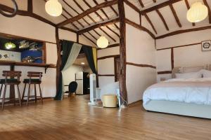 a bedroom with a bed and a kitchen with a bar at Hue Hanok Guesthouse in Buan