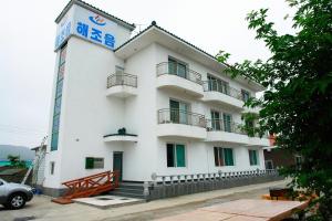 a white building with a sign on the side of it at Buan Byeonsanbando Haejoeum Pension in Buan +8 photos