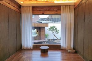a room with a large window with a tree outside at Stay Hanul Jacuzzi Private Pension in Jeonju