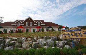a house with a sign in front of a rock wall at Namdangrodem Pension in Hongseong