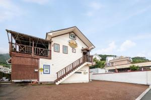 a white building with a staircase on the side of it at Geoje ireece Pension in Geoje 