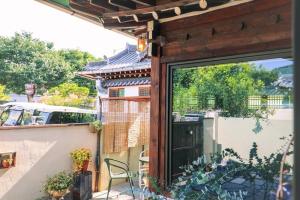 a patio with a sliding glass door with a table and chairs at Happiness on Jacuzzi Private Pension in Jeonju