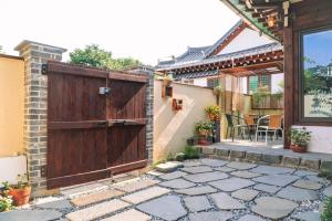 an outdoor patio with a wooden gate and a patio at Happiness on Jacuzzi Private Pension in Jeonju