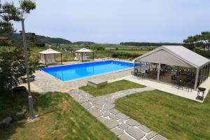 a swimming pool with a gazebo next to at Buan Ravich pet Friendly Pension in Buan