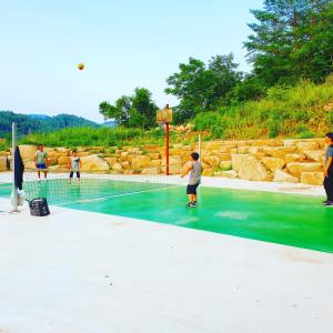 a group of people playing tennis on a tennis court at Gangreung refresh odaesanjeom in Gangneung +53 photos