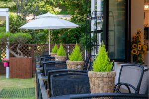 a row of chairs with an umbrella on a patio at Suncheon raon house egyeon pension in Suncheon